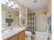 Bright bathroom featuring a shower and tub with striped curtain and neutral vanity at 1199 Mathews Ln, The Villages, FL 32162