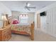 Well-lit bedroom with a ceiling fan, complemented by neutral carpet and a window at 1199 Mathews Ln, The Villages, FL 32162