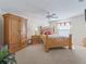 Cozy bedroom with a ceiling fan, neutral carpet, complemented by elegant wooden furniture at 1199 Mathews Ln, The Villages, FL 32162