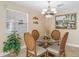 Cozy dining area with a glass table, chandelier, and large window with natural light at 1199 Mathews Ln, The Villages, FL 32162