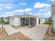 Rear view of the residence featuring a screened-in porch and a well-maintained yard at 1199 Mathews Ln, The Villages, FL 32162