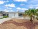 Charming home featuring a well-maintained front yard with a decorative rock garden and a white picket fence at 1199 Mathews Ln, The Villages, FL 32162