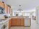 Open kitchen showcasing stainless steel sink and dishwasher with a view of the living and dining areas at 1199 Mathews Ln, The Villages, FL 32162