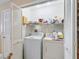 Bright laundry room featuring a washer, dryer, and shelving for storage at 1199 Mathews Ln, The Villages, FL 32162