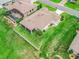 Aerial view of home, backyard, and screened pool and lanai with mature landscaping and retaining wall at 12198 Se 176Th Loop, Summerfield, FL 34491