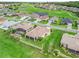 Aerial view of home with golf course community, mature landscaping and large pond at 12198 Se 176Th Loop, Summerfield, FL 34491