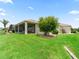 Well-maintained backyard with lush lawn, mature landscaping, and screened-in porch for outdoor enjoyment at 12198 Se 176Th Loop, Summerfield, FL 34491