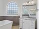 Bathroom with arched window and vanity with granite countertops at 12198 Se 176Th Loop, Summerfield, FL 34491