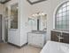 Bathroom showcasing a glass shower, vanity with granite countertops, and arched window at 12198 Se 176Th Loop, Summerfield, FL 34491