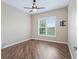 Bedroom featuring wood floors and view of lush backyard through a sunny window at 12198 Se 176Th Loop, Summerfield, FL 34491