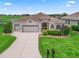 Single-story home with a well-maintained lawn, attached two-car garage, and manicured landscaping at 12198 Se 176Th Loop, Summerfield, FL 34491