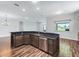 Open kitchen features granite counters, stainless appliances, and wood-look tile flooring at 12198 Se 176Th Loop, Summerfield, FL 34491