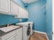 Bright laundry room with white cabinets, sink, washer, and dryer at 12198 Se 176Th Loop, Summerfield, FL 34491