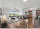 Open-concept living room with wood-look floors and views to the outdoor patio and golf course at 12198 Se 176Th Loop, Summerfield, FL 34491