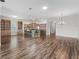 Open-concept living space with wood-look tile, kitchen island, and built-in bookshelves at 12198 Se 176Th Loop, Summerfield, FL 34491