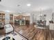 Open-concept living space with wood-look tile, kitchen island, and adjacent dining area at 12198 Se 176Th Loop, Summerfield, FL 34491