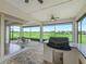 Outdoor kitchen with view of golf course features a built-in grill, mini fridge, and stylish brick flooring at 12198 Se 176Th Loop, Summerfield, FL 34491