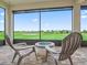 Relaxing screened patio with golf course views, seating, and stylish brick flooring at 12198 Se 176Th Loop, Summerfield, FL 34491