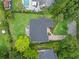 Aerial view of a house featuring a dark roof, green backyard, a pool, and a patio area at 1237 Mercedes Pl, Orlando, FL 32804