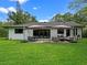 Expansive backyard with a patio, dining table, lounge seating, and lush green grass at 1237 Mercedes Pl, Orlando, FL 32804