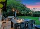 Inviting backyard with an outdoor dining area, lounge seating, and lush landscaping at dusk at 1237 Mercedes Pl, Orlando, FL 32804