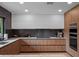 Modern kitchen with wood cabinetry, dark backsplash, and natural light at 1237 Mercedes Pl, Orlando, FL 32804