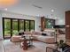 Open-concept living room with a fireplace, sleek furniture, and a view of the backyard and modern kitchen at 1237 Mercedes Pl, Orlando, FL 32804