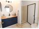 Stylish bathroom with modern vanity, circular mirror, and a convenient walk-in shower at 1325 Balboa Ct, The Villages, FL 32159