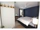 Inviting bedroom with blue accent wall, a ceiling fan, and a window view at 1325 Balboa Ct, The Villages, FL 32159