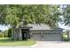 Inviting single-story home showcases a well-maintained lawn, lush landscaping, and a convenient three-car garage at 1355 Misty Glen Ln, Clermont, FL 34711