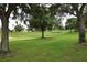 Picturesque golf course showcasing lush green lawns, mature trees, and the community name spelled out, creating a serene landscape at 1355 Misty Glen Ln, Clermont, FL 34711