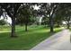 Well-maintained golf course featuring mature trees and scenic walking path at 1355 Misty Glen Ln, Clermont, FL 34711