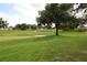 Scenic golf course view featuring lush green lawns, sand traps, mature trees, and the community name spelled out in large letters at 1355 Misty Glen Ln, Clermont, FL 34711