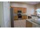 Well-equipped kitchen showcases stainless steel appliances, light wood cabinetry, and ample counter space for cooking and prep at 1355 Misty Glen Ln, Clermont, FL 34711