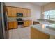 Modern kitchen with stainless steel appliances, wood cabinets, and neutral countertops, perfect for culinary enthusiasts at 1355 Misty Glen Ln, Clermont, FL 34711
