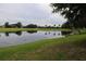 Serene pond reflecting the surrounding greenery of the golf course community at 1355 Misty Glen Ln, Clermont, FL 34711
