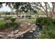Beautiful stream and water feature at community entrance with tropical plants and stone accents at 1355 Misty Glen Ln, Clermont, FL 34711