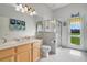 Bright bathroom with a decorative mirror, and a glass shower with door to exterior at 1426 Lakemist Ln, Clermont, FL 34711