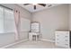 Bright bedroom with a work desk, a window with light pink curtains, and white dressers at 1426 Lakemist Ln, Clermont, FL 34711