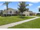 Charming single-story home featuring a manicured lawn, mature landscaping, and a three-car garage at 1426 Lakemist Ln, Clermont, FL 34711