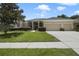 Attractive single-story home featuring a well-manicured lawn and a three-car garage at 1426 Lakemist Ln, Clermont, FL 34711