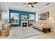 Comfortable living room with a fireplace, bright windows, and a ceiling fan at 1426 Lakemist Ln, Clermont, FL 34711