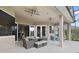 Covered outdoor living space with comfortable seating, ceiling fans, and views of the pool and backyard at 1426 Lakemist Ln, Clermont, FL 34711