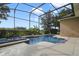 Inviting screened-in pool and spa surrounded by lush landscaping and a spacious patio at 1426 Lakemist Ln, Clermont, FL 34711