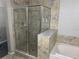 Bathroom with a glass-enclosed shower and a soaking tub surrounded by neutral tile at 14501 Grove Resort Ave # 3406, Winter Garden, FL 34787