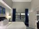 Bright and airy bedroom with a queen-size bed, blue curtains, and natural light from the window at 14501 Grove Resort Ave # 3406, Winter Garden, FL 34787