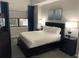 Comfortable bedroom with a queen-size bed, dark wood furniture, and a window with natural light at 14501 Grove Resort Ave # 3406, Winter Garden, FL 34787