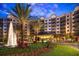Beautiful exterior view of a condo building with a fountain, palm trees, and manicured landscaping at 14501 Grove Resort Ave # 3406, Winter Garden, FL 34787