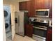 Functional kitchen with stainless steel appliances, dark wood cabinets, and adjacent laundry room at 14501 Grove Resort Ave # 3406, Winter Garden, FL 34787