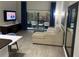 Comfortable living room featuring a plush sofa, television, and sliding door access to the screened patio at 14501 Grove Resort Ave # 3406, Winter Garden, FL 34787